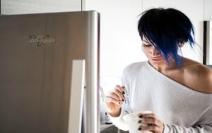 woman eating ice cream at fridge