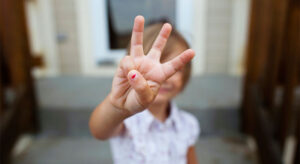 little girl holding up 3 fingers