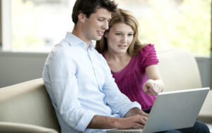man and woman looking at computer for homes